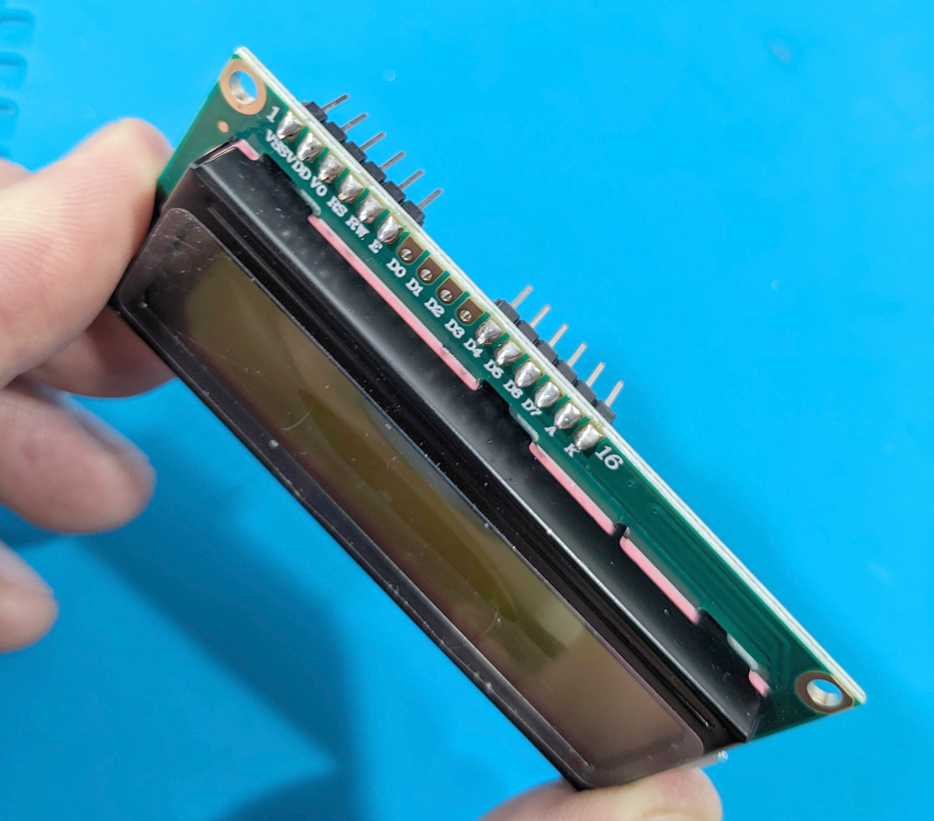 LCD with male headers soldered to outer 6 pads on each end